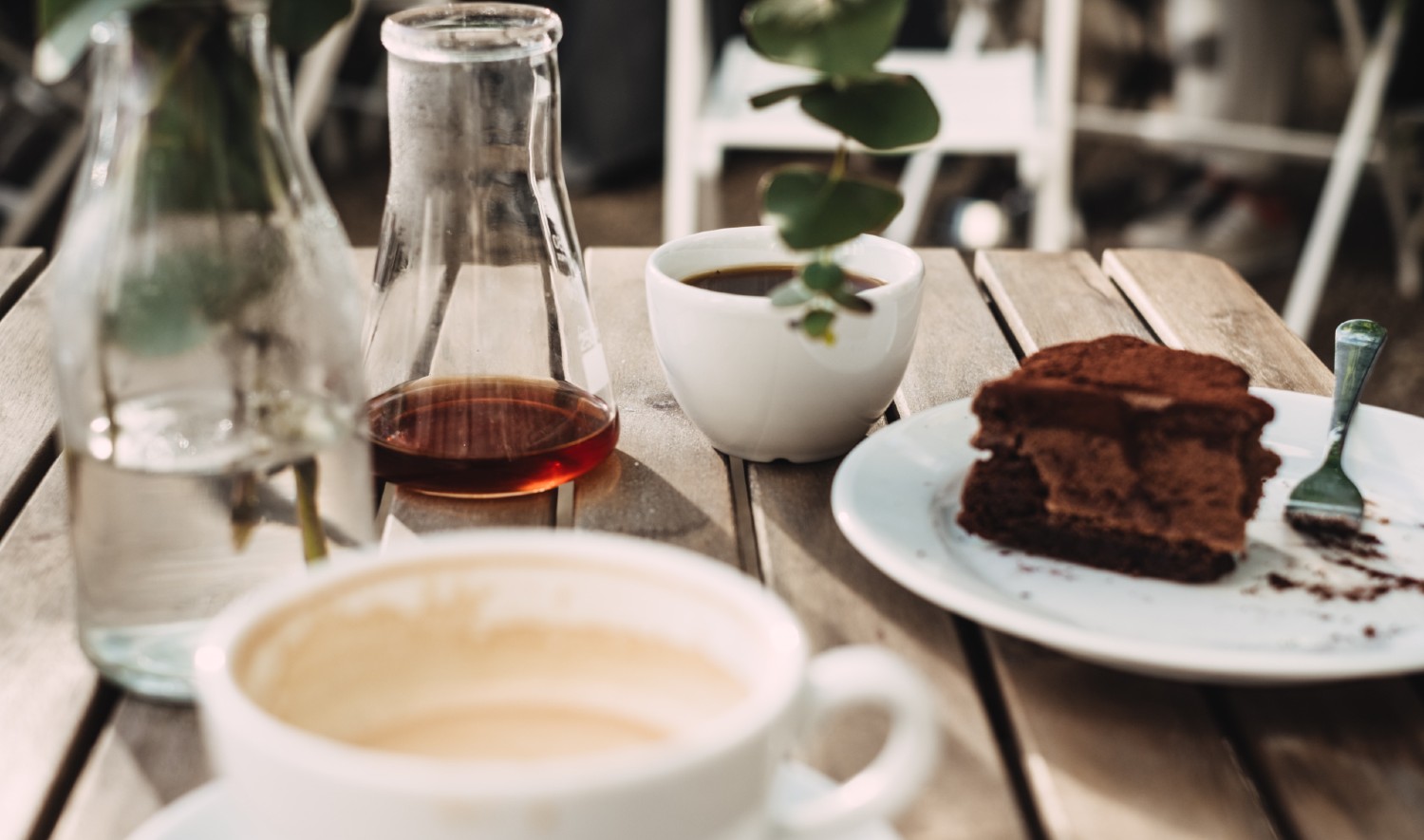 Tafel met kopjes koffie, stukje taart op een schoteltje